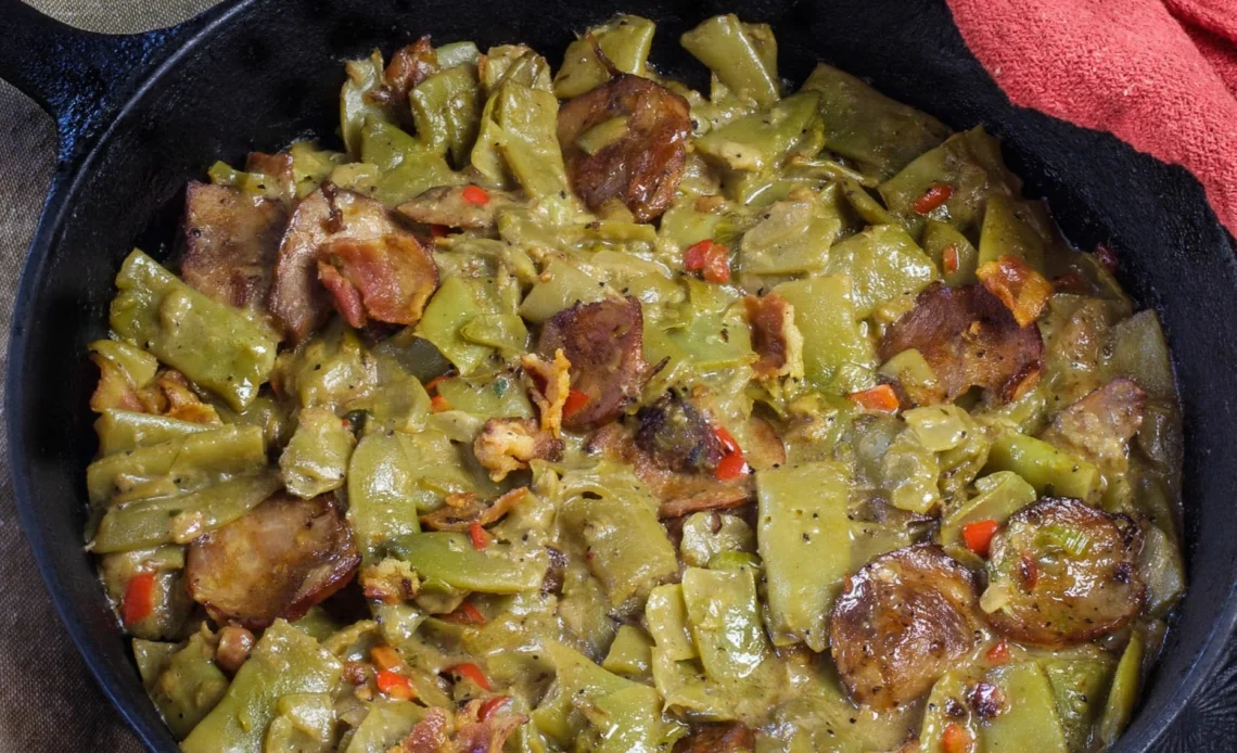 Dish of Creole Smothered Green Beans with Andouille Sausage garnished with herbs