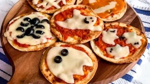 Easy mini Halloween pizzas shaped like ghosts and pumpkins for spooky celebrations.
