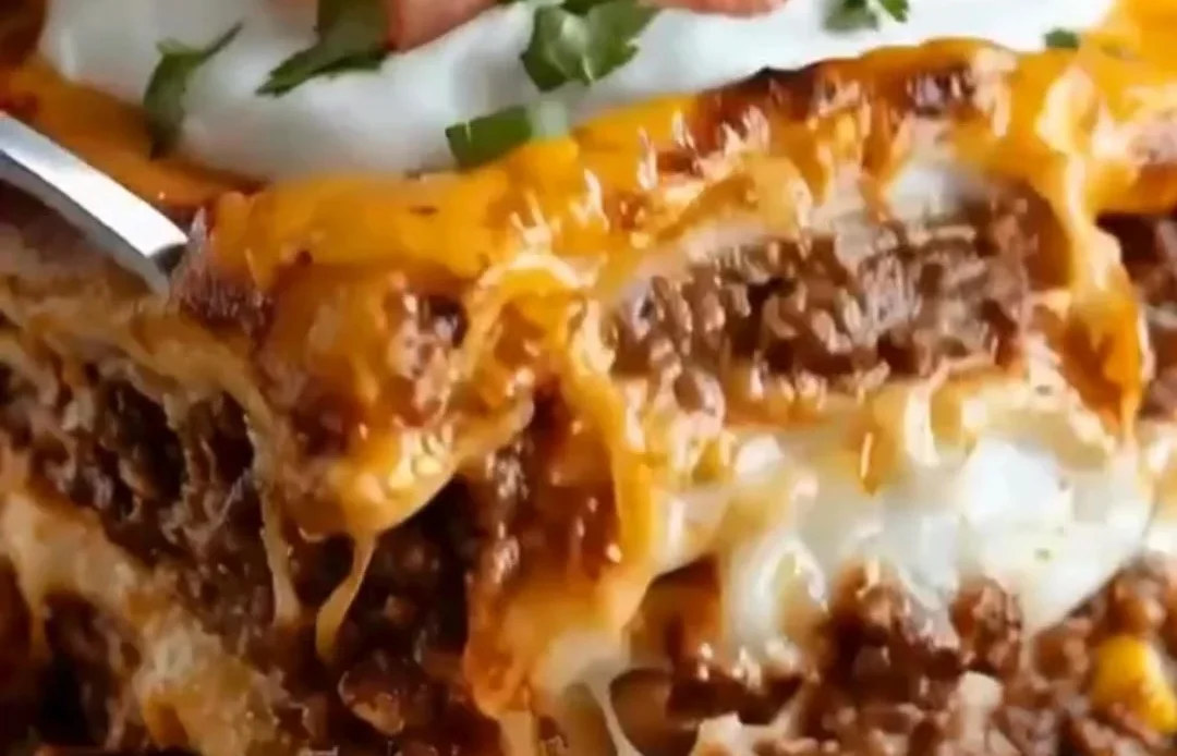 Cheesy Taco Lasagna Bake with layers of tortillas, meat, cheese, and toppings
