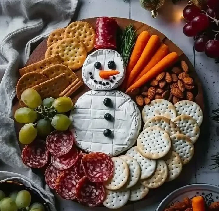 Delicious Christmas Snowman cheese board with festive decorations and treats.