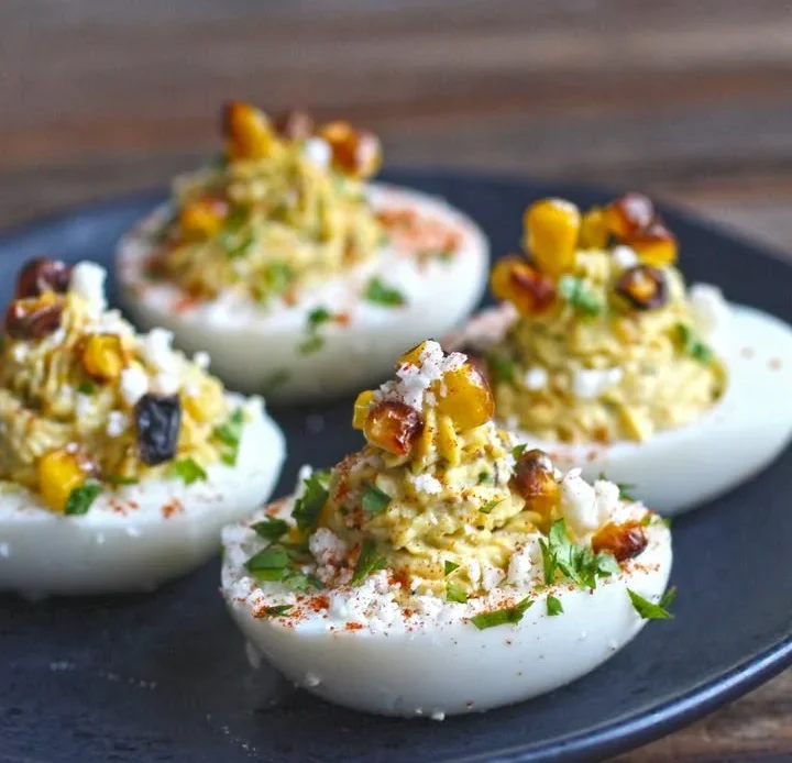 Corn elote deviled eggs topped with spices and cilantro.