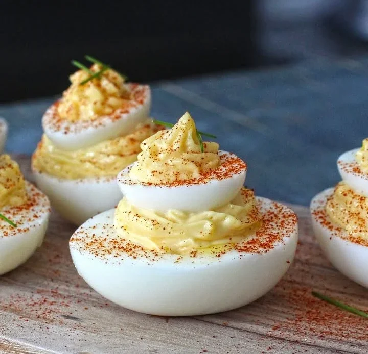 Delicious and creamy deviled eggs garnished with paprika and herbs