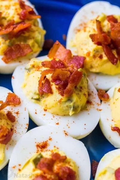 Plate of delicious deviled eggs garnished with paprika and herbs