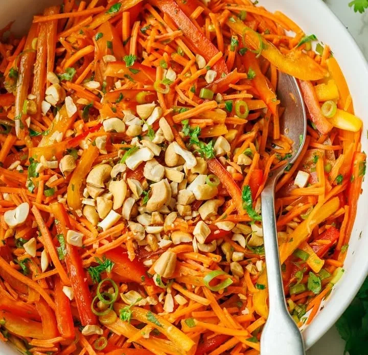 Bowl of spicy Korean carrot salad with fresh herbs and spices