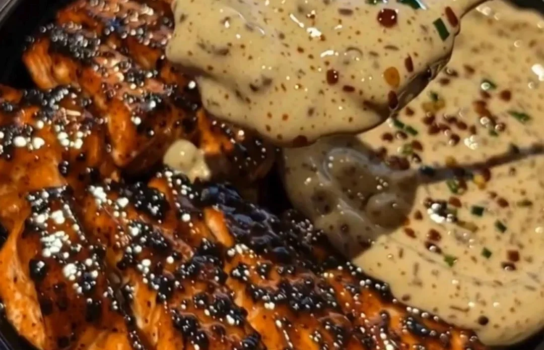 Sticky honey butter salmon garnished with herbs on a plate
