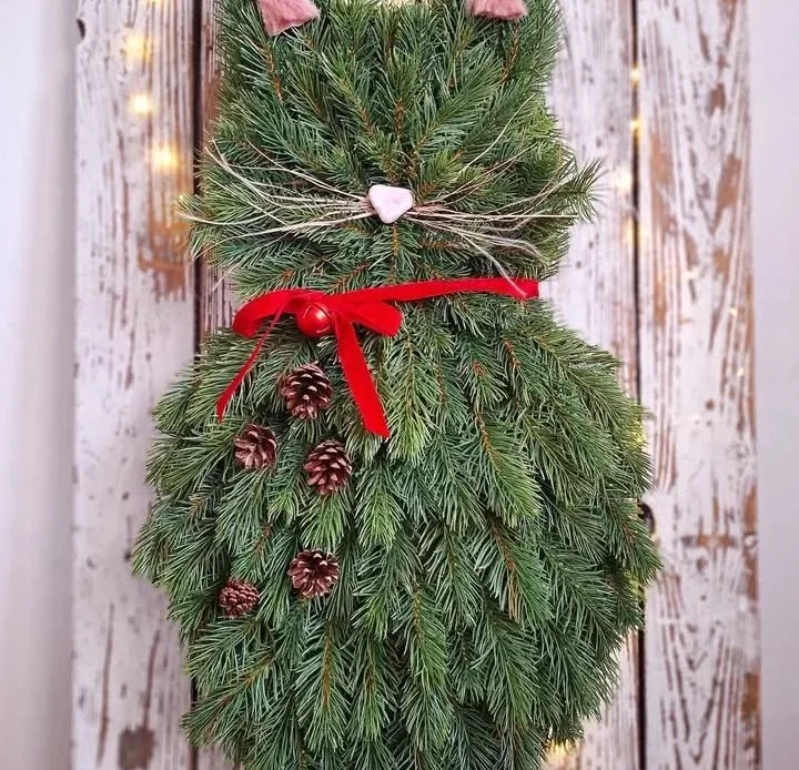 DIY cat wreath with pine branches and a red bow for festive decor