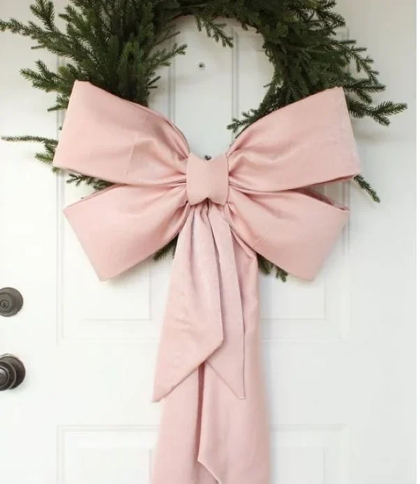 DIY Christmas wreath with a large blush pink bow for festive decoration