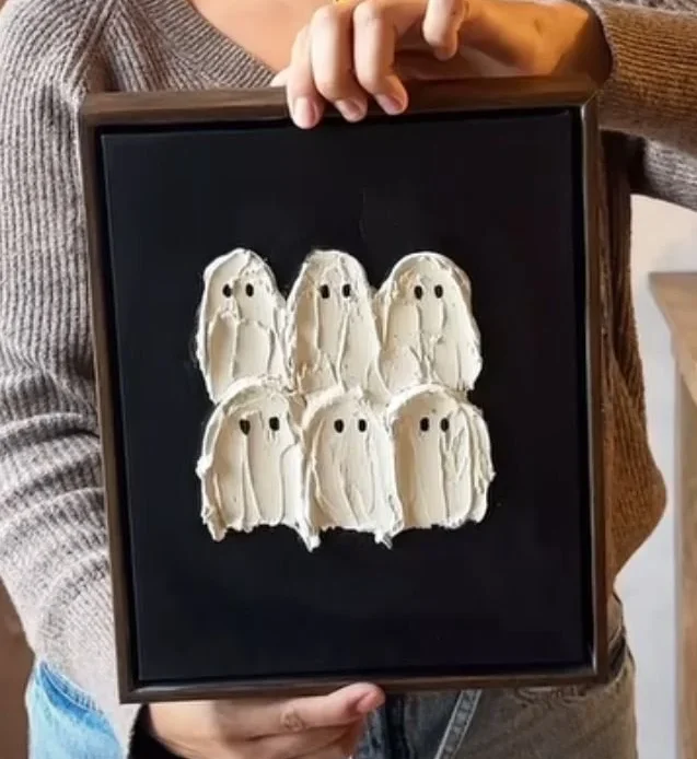 DIY Halloween ghost painting on a dark background with textured paint.