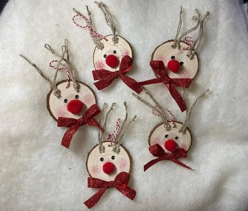 DIY wooden reindeer ornaments crafted from wood slices and adorned with red bows.