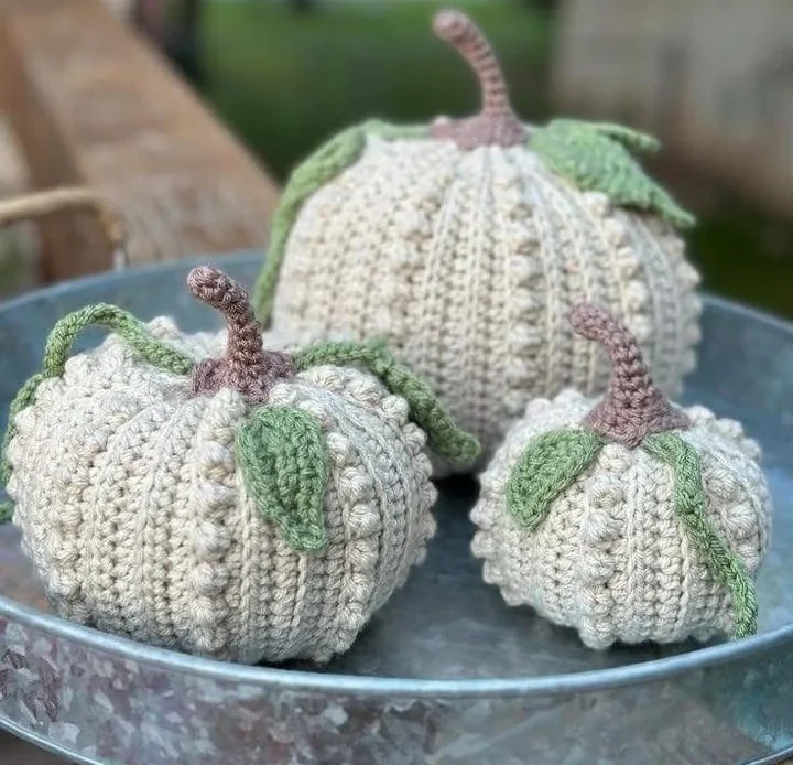 Hand-crocheted decorative pumpkins in beige with soft green leaves