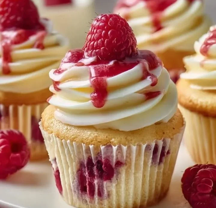 Heavenly raspberry cheesecake cupcakes topped with fresh raspberries and creamy frosting.