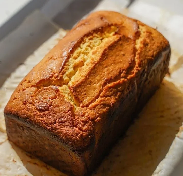 Slice of Lemon Miso Pound Cake topped with lemon zest and a drizzle of glaze